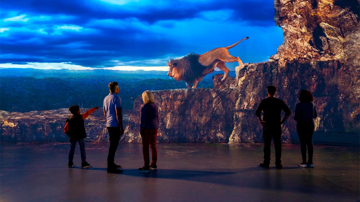 People are standing in front of the lion painting.